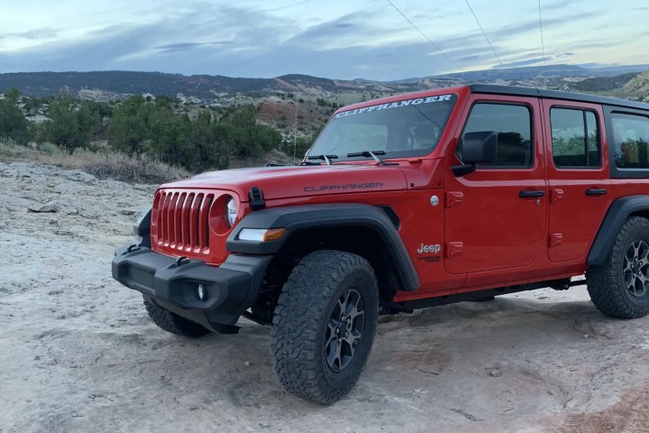 a red truck driving down a dirt road